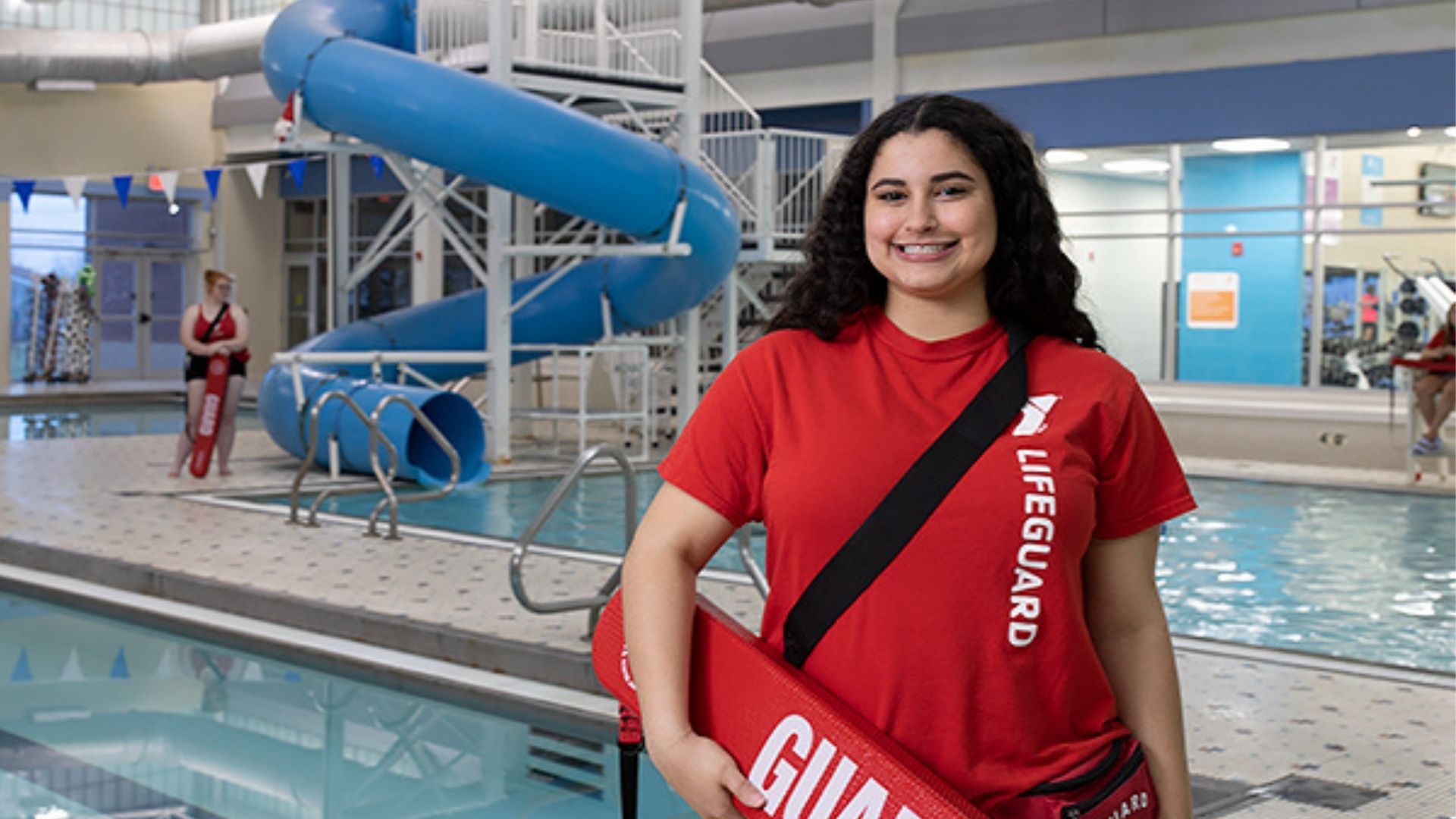 Smiling lifeguard standing next to family pool Smiling lifeguard standing next to family pool
