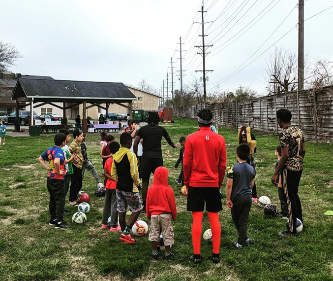 Group of adults and children outside with soccer balls Group of adults and children outside with soccer balls