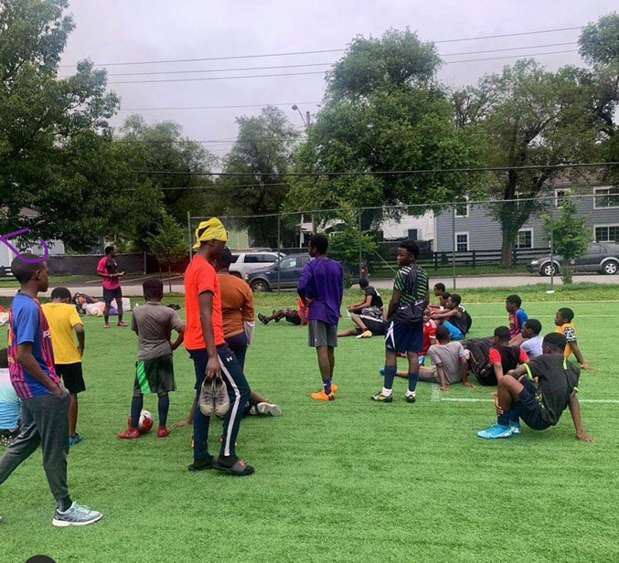 Group of adults and children outside in a soccer field Group of adults and children outside in a soccer field