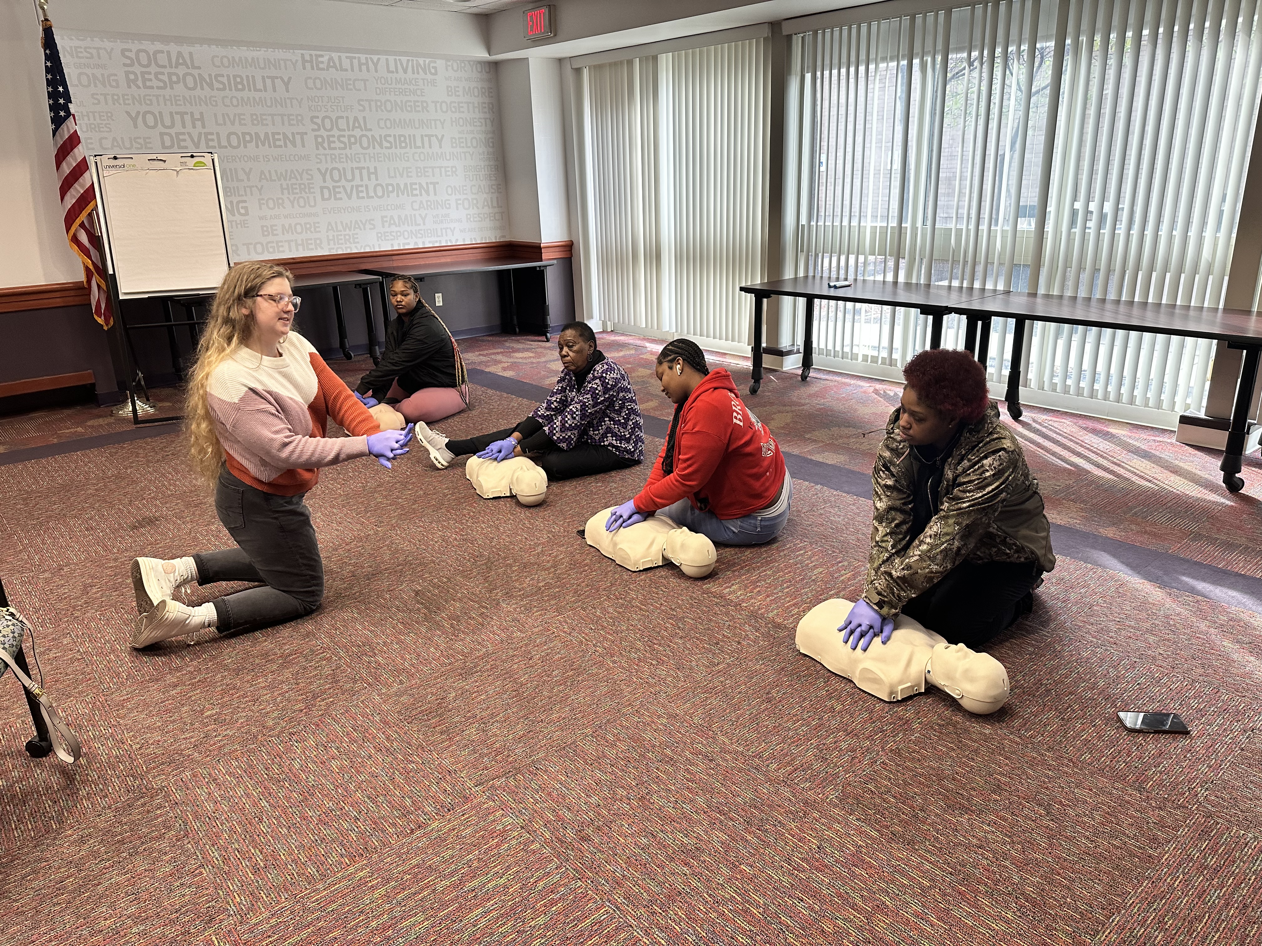 A person teaching a CPR class to a group of people A person teaching a CPR class to a group of people