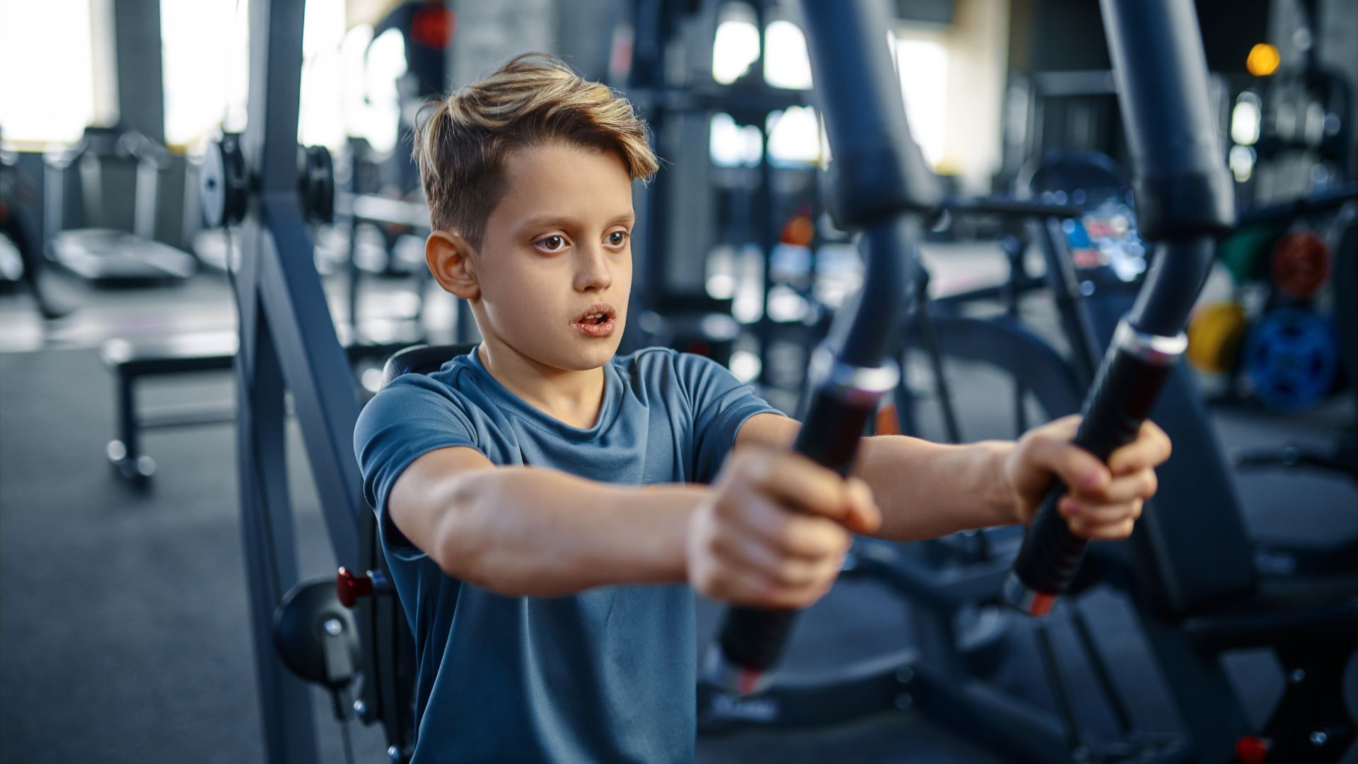 Teenager using weight machine Teenager using weight machine