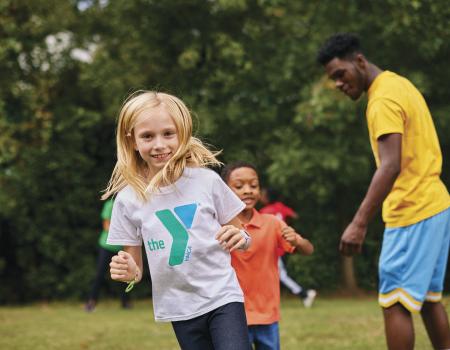 Smiling girl in YMCA shirt running outdoors Smiling girl in YMCA shirt running outdoors