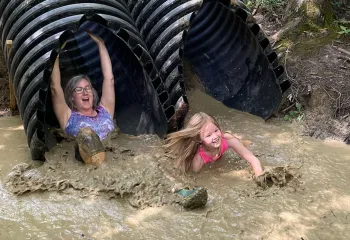 Kids going down a slide in the YMCA Mud Run