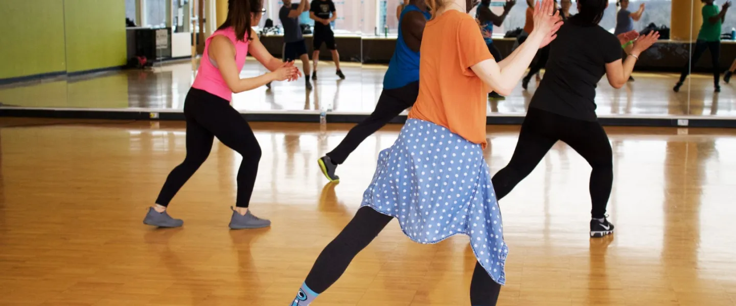 Adults dancing and clapping at group dance class