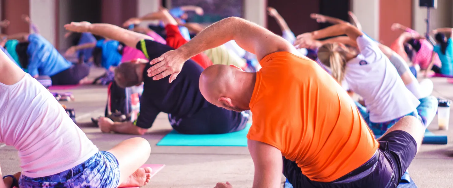 Group of adults doing side stretches at mind and body class