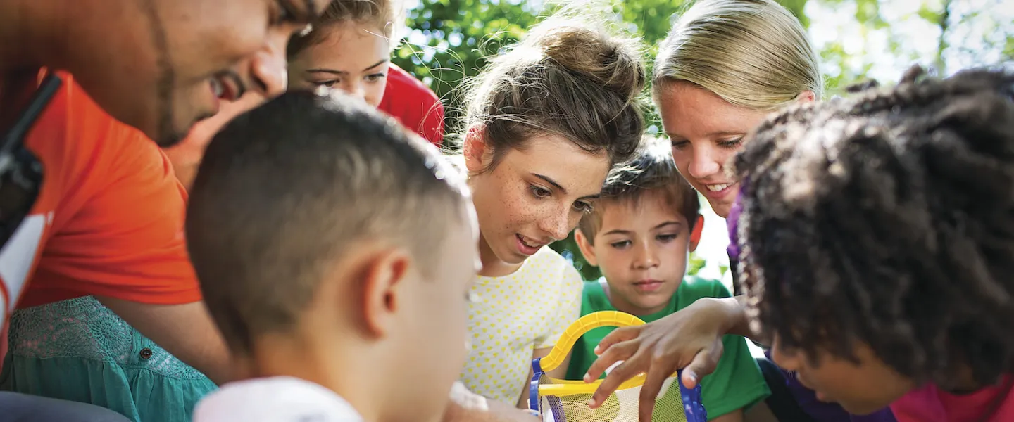 Children surrounding YMCA camp counselor at YMCA Louisville Summer Day Camps