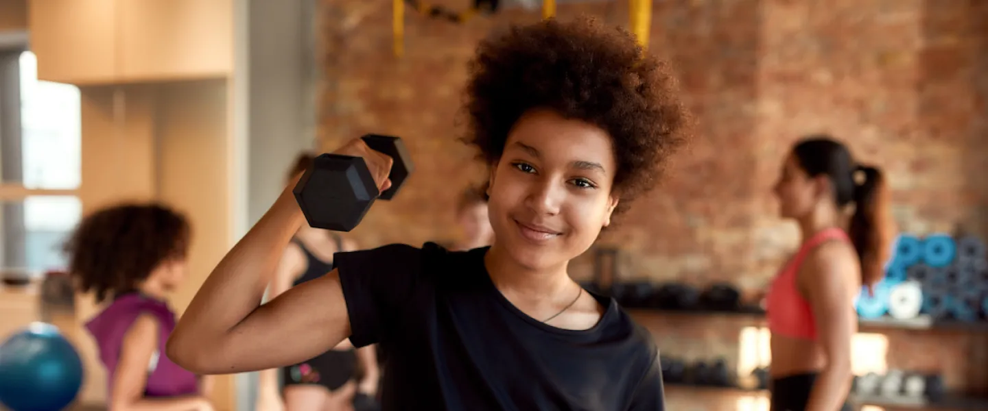 Kid lifting weights for youth exercise program