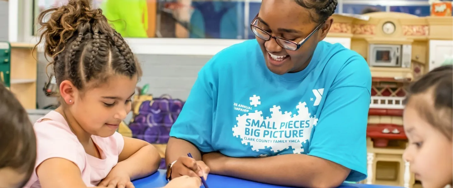 Kids' Club staff member doing crafts with happy young children