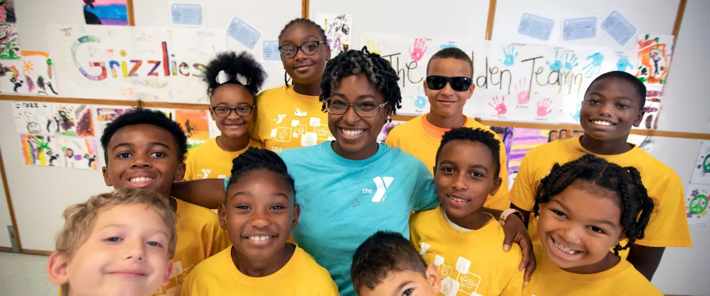 Child care staff member standing with a group of children