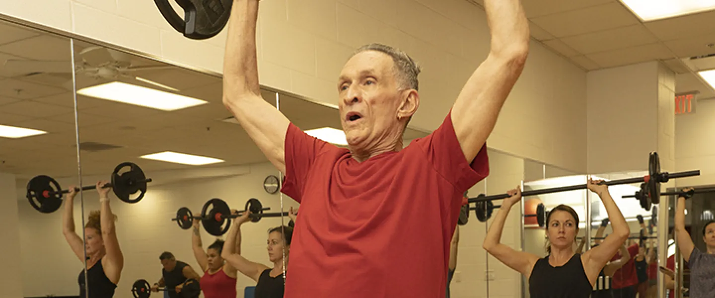 People with barbells in a YMCA strength group fitness class