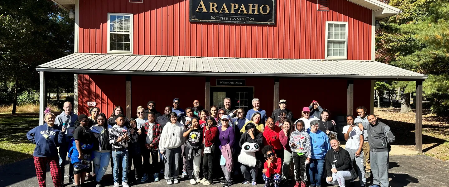 Group of people standing in front of a large red building