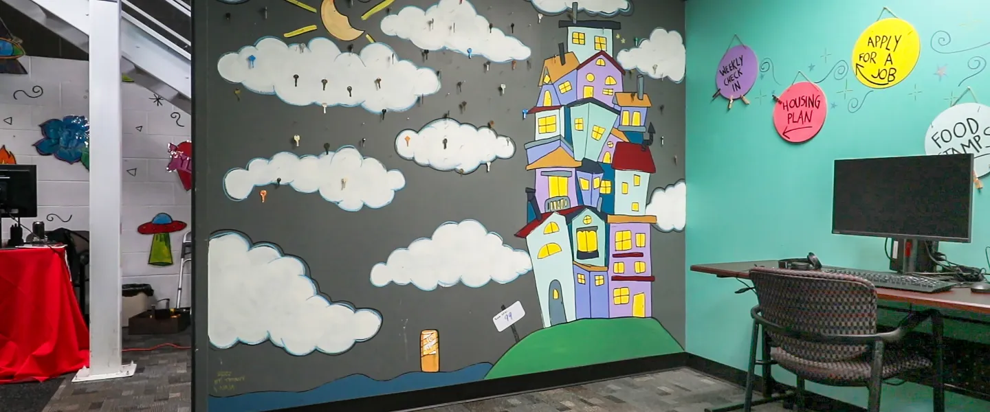 Painted mural of clouds and buildings on a wall 