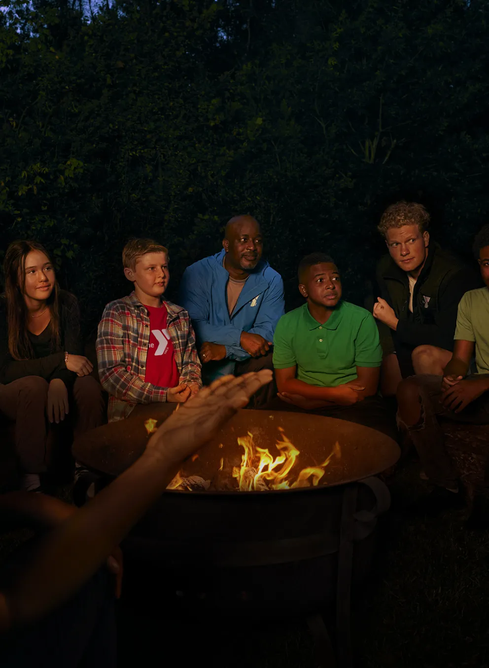 Children and camp counselors around campfire at YMCA Camp Piomingo