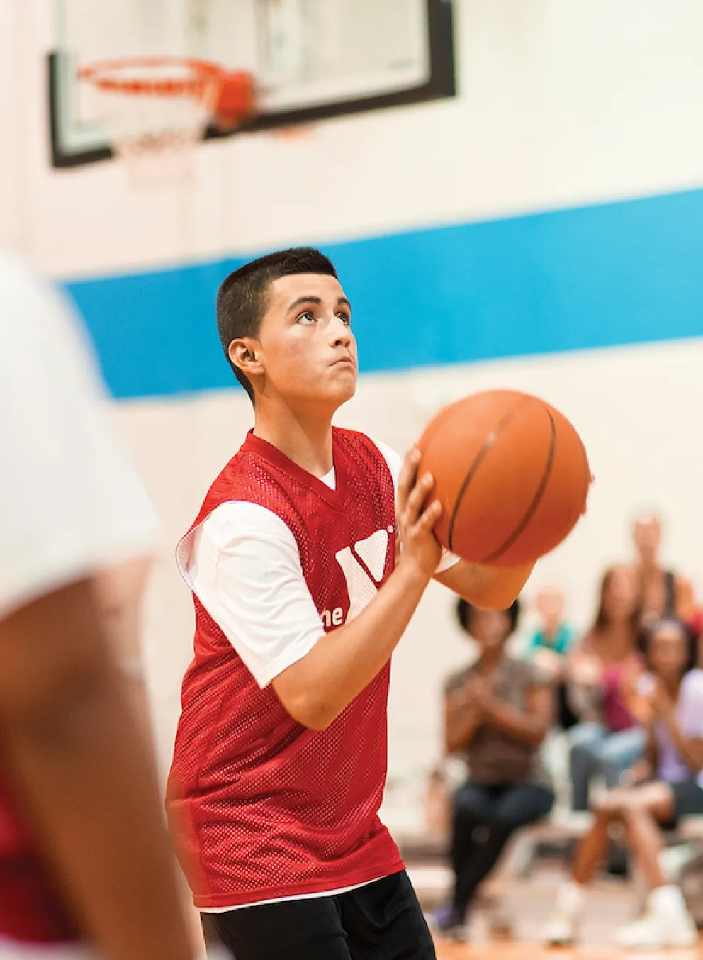Kid shooting basketball during youth basketball league game
