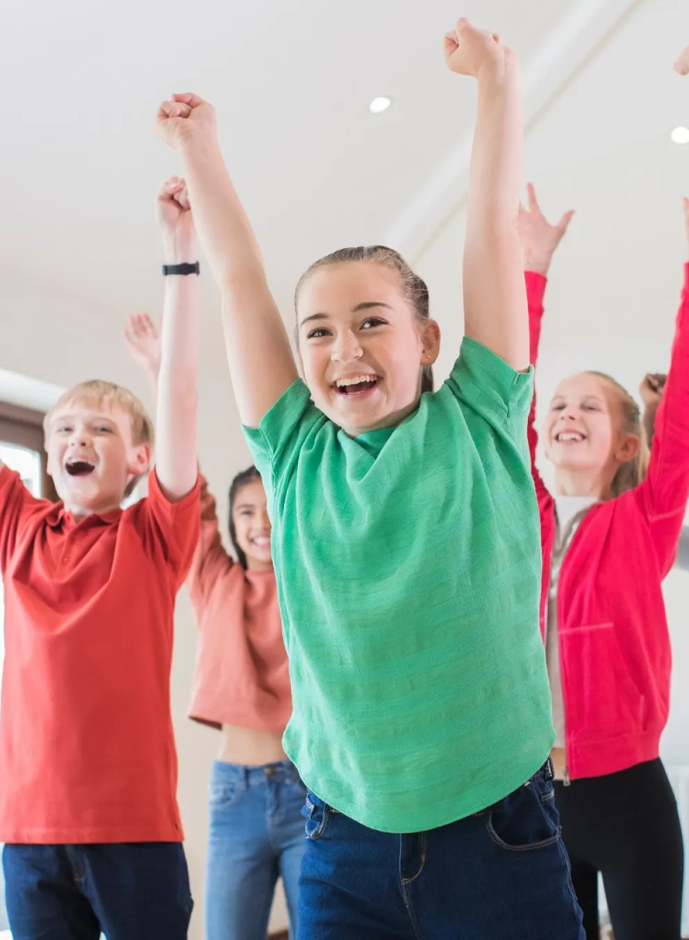 Kids raising hands in the air, celebrating and dancing together