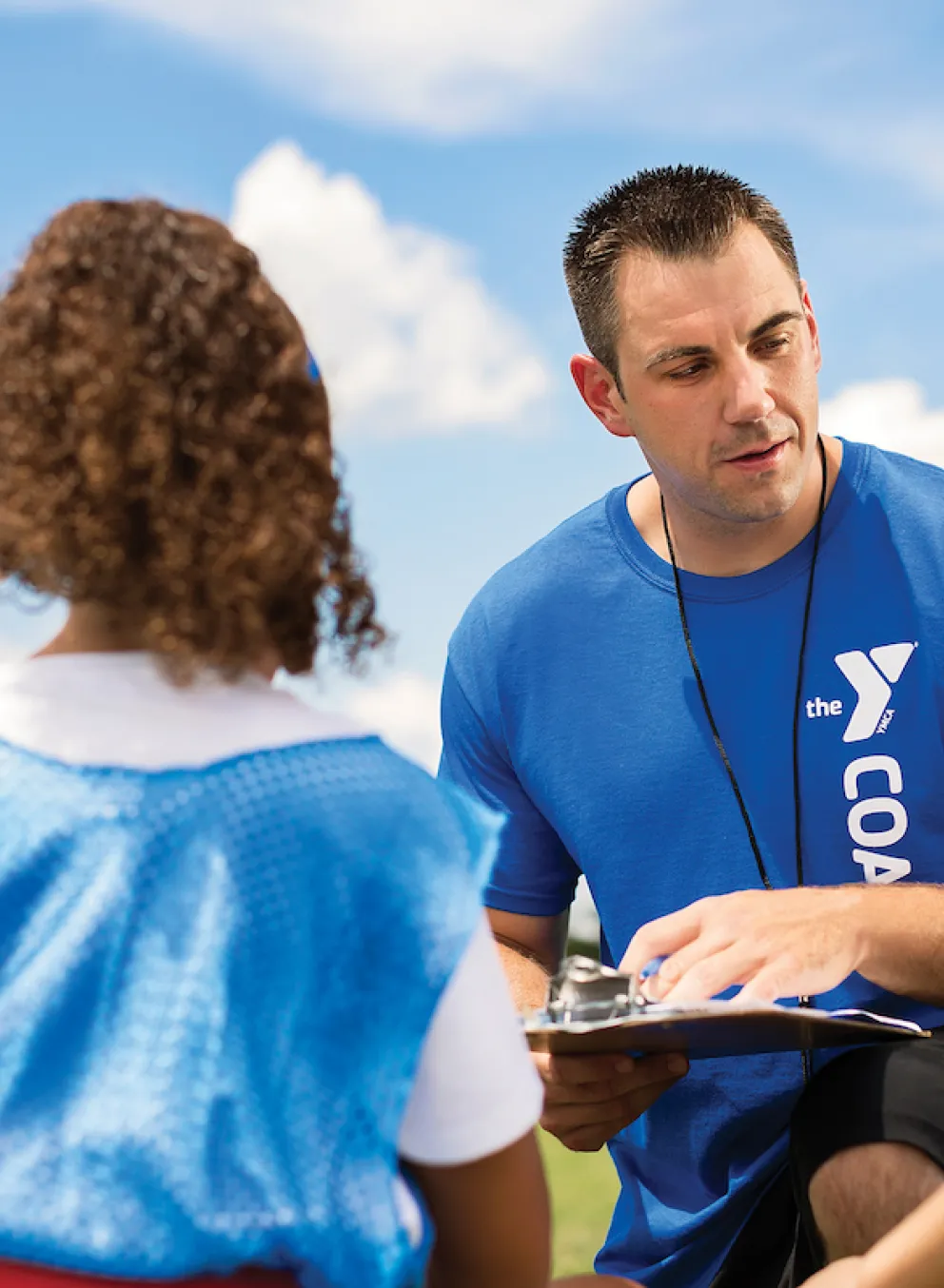 Coach talking to kids for YMCA Louisville youth fitness program