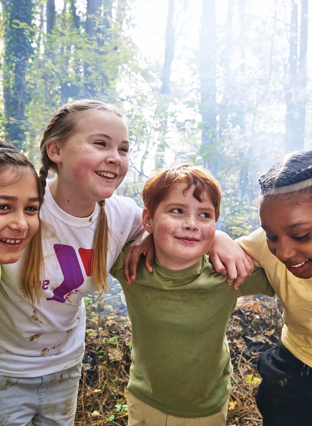 Group of kids outdoors in a circle smiling