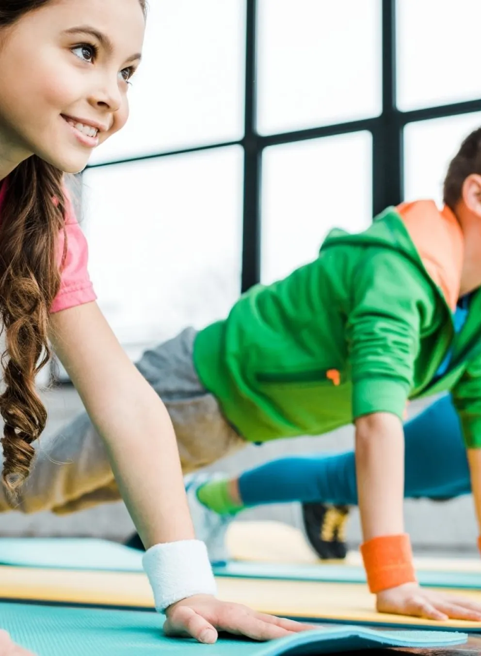 Group of three children smiling and doing push ups