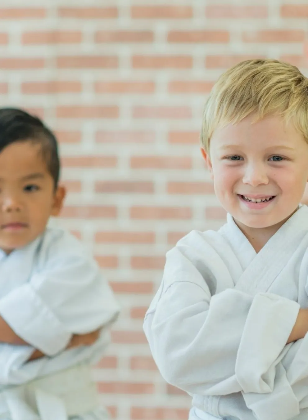 Smiling kids in white martial arts uniforms