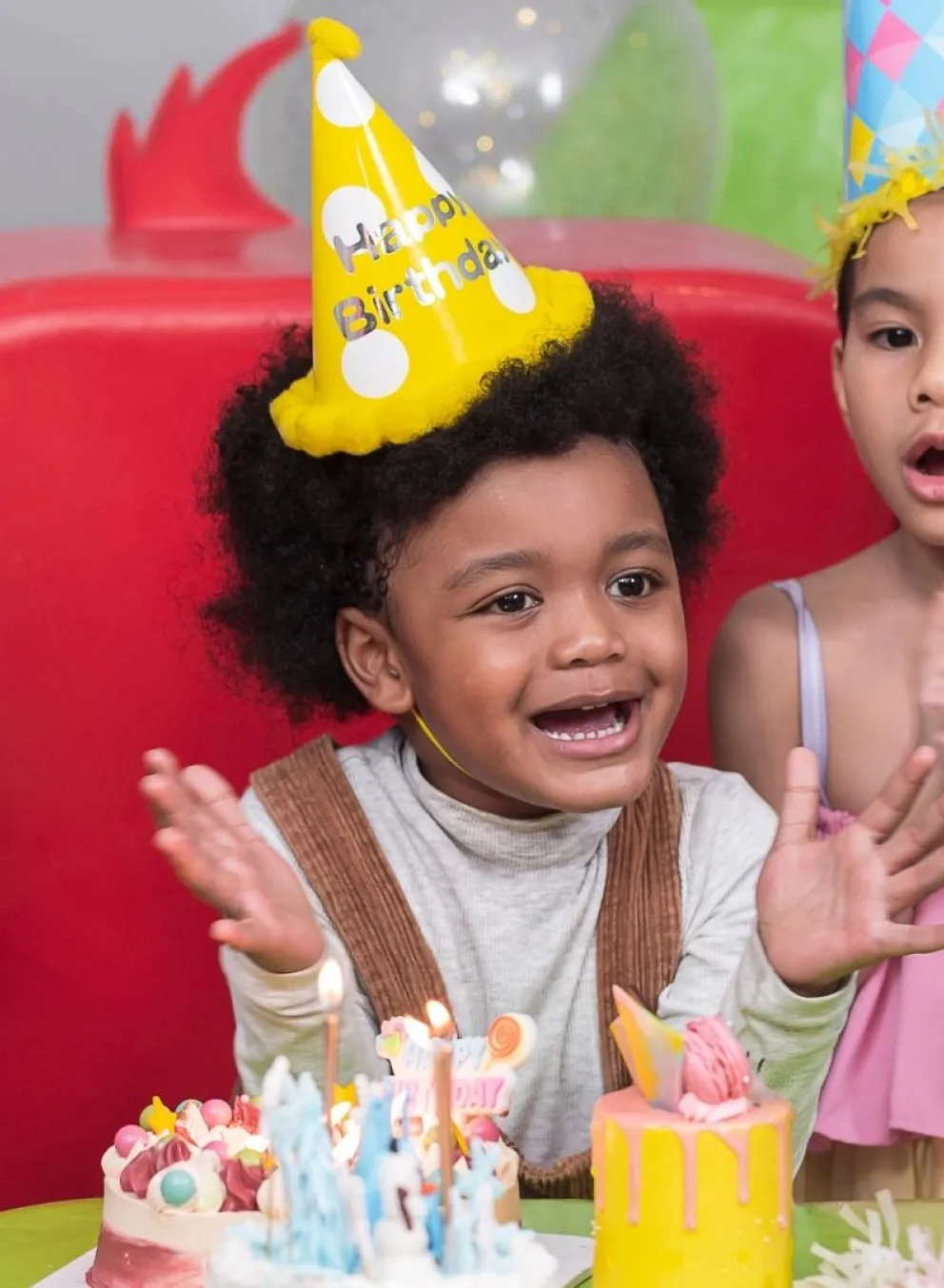 Group of kids in party hats clapping hands