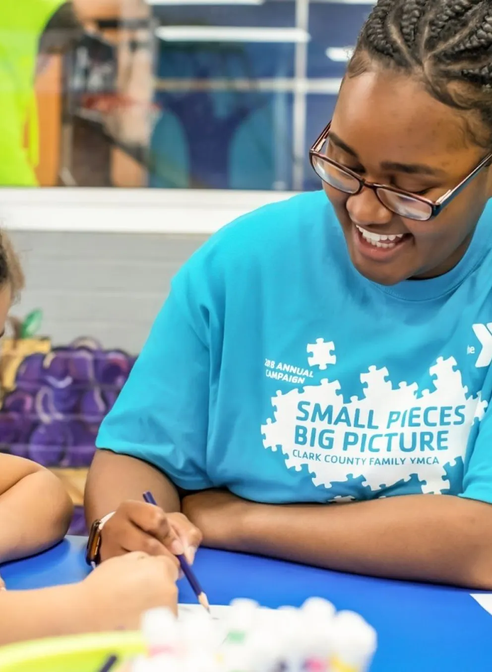 Kids' Club staff member doing crafts with happy young children