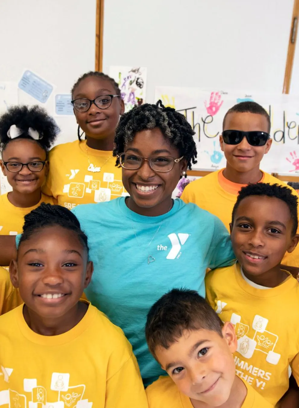 Child care staff member standing with a group of children