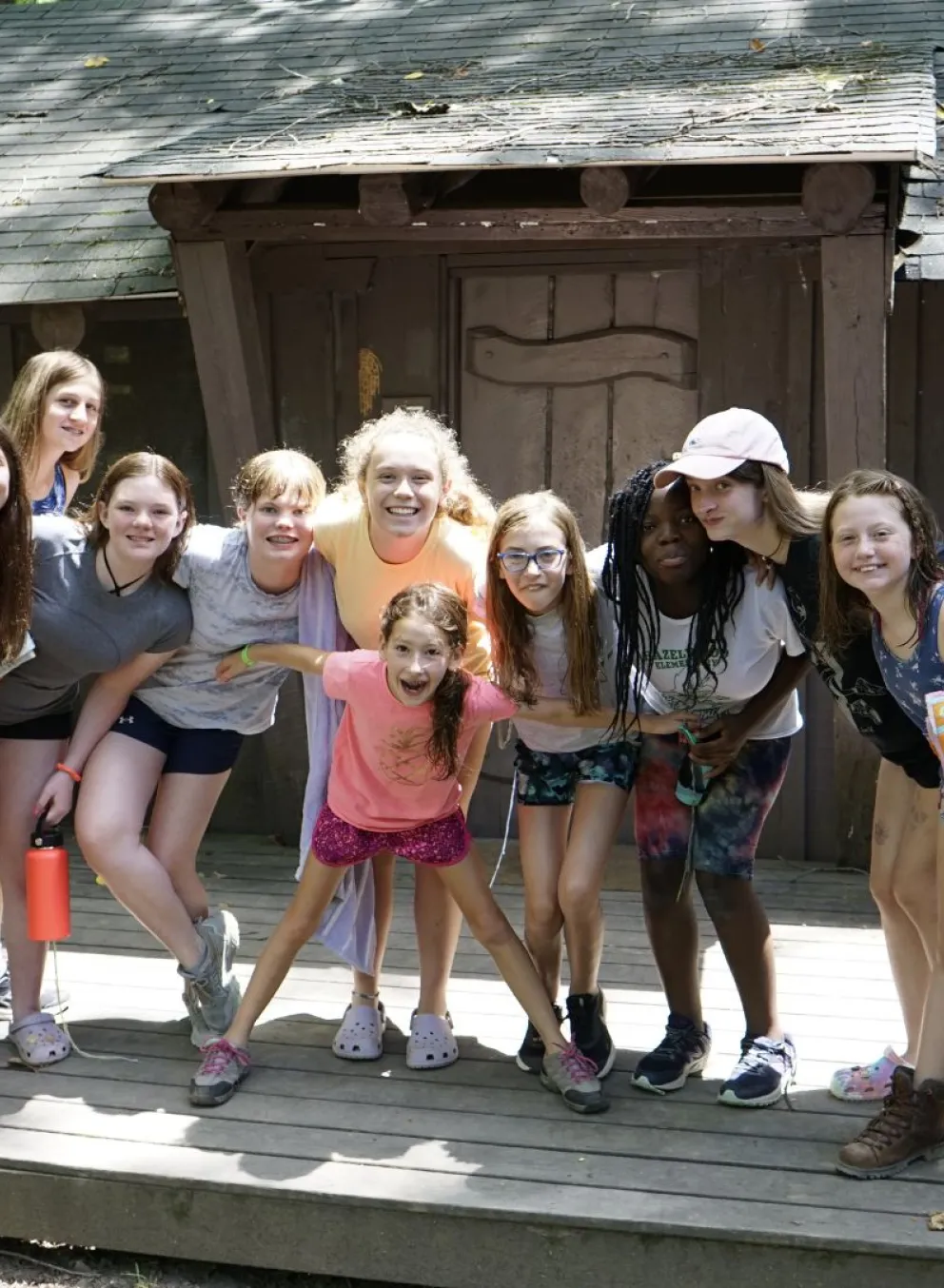 Group of campers standing together outside of their cabin at YMCA Camp Piomingo