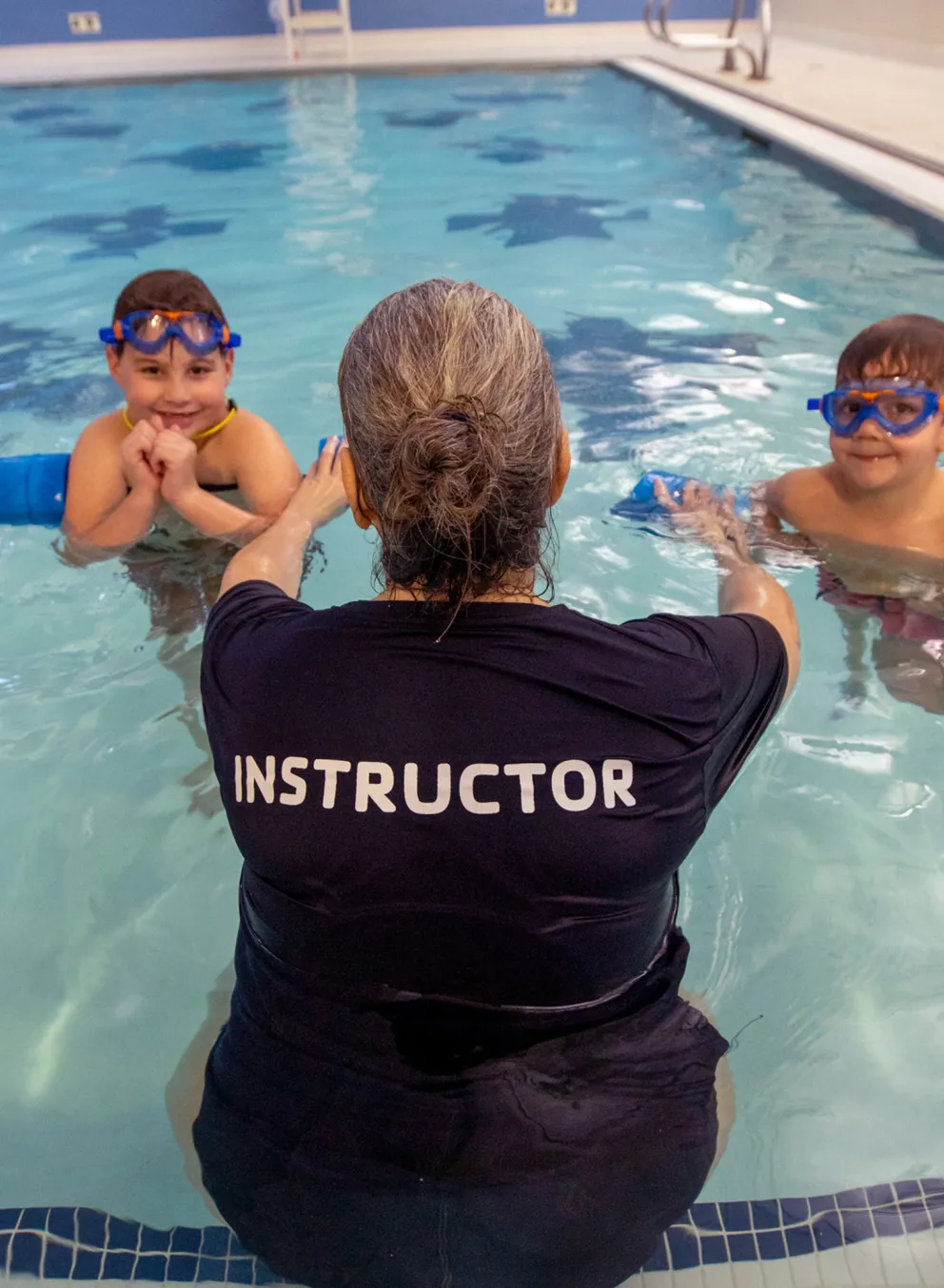 Swim instructor with two boys