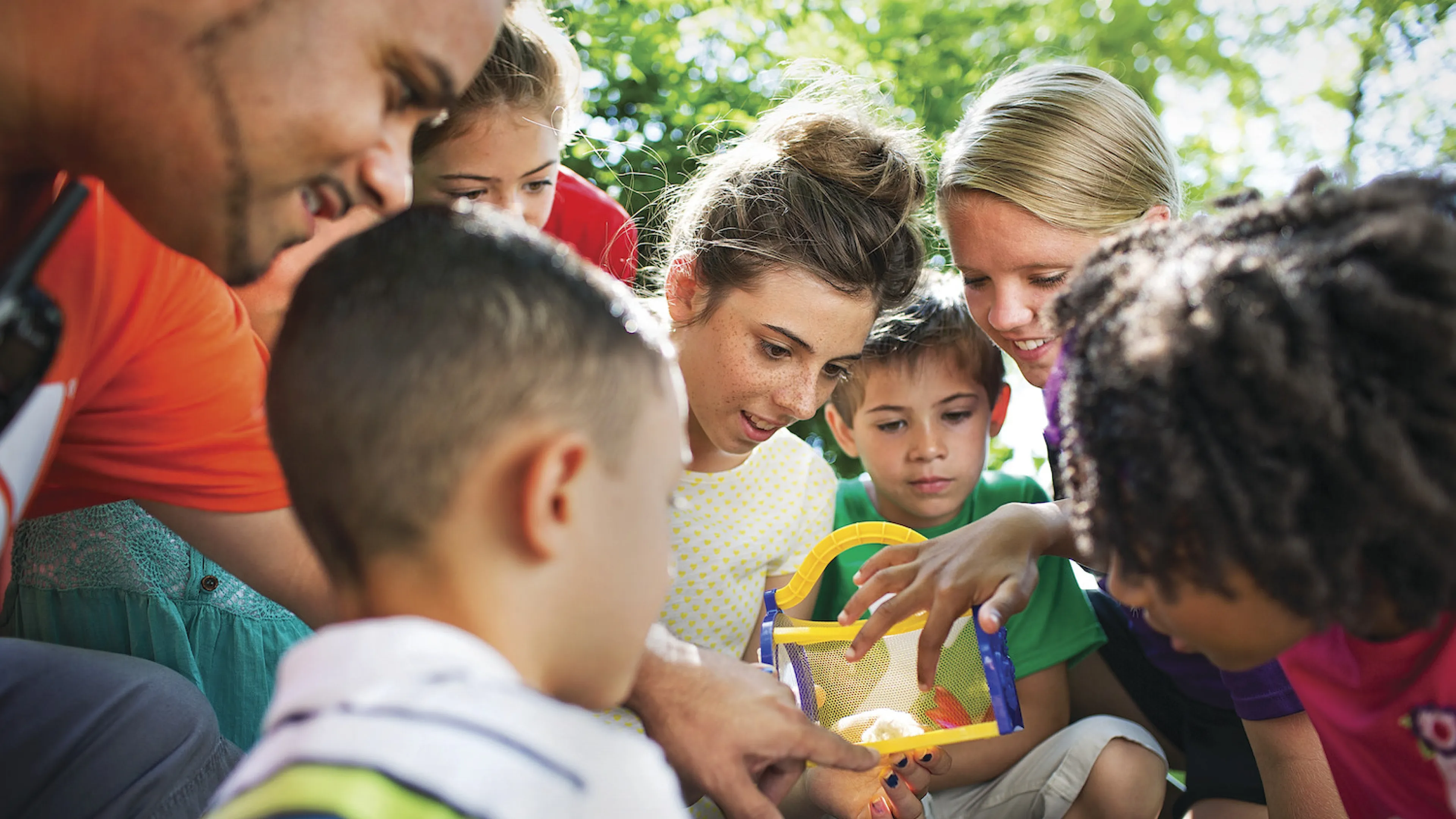 Children surrounding YMCA camp counselor at YMCA Louisville Summer Day Camps