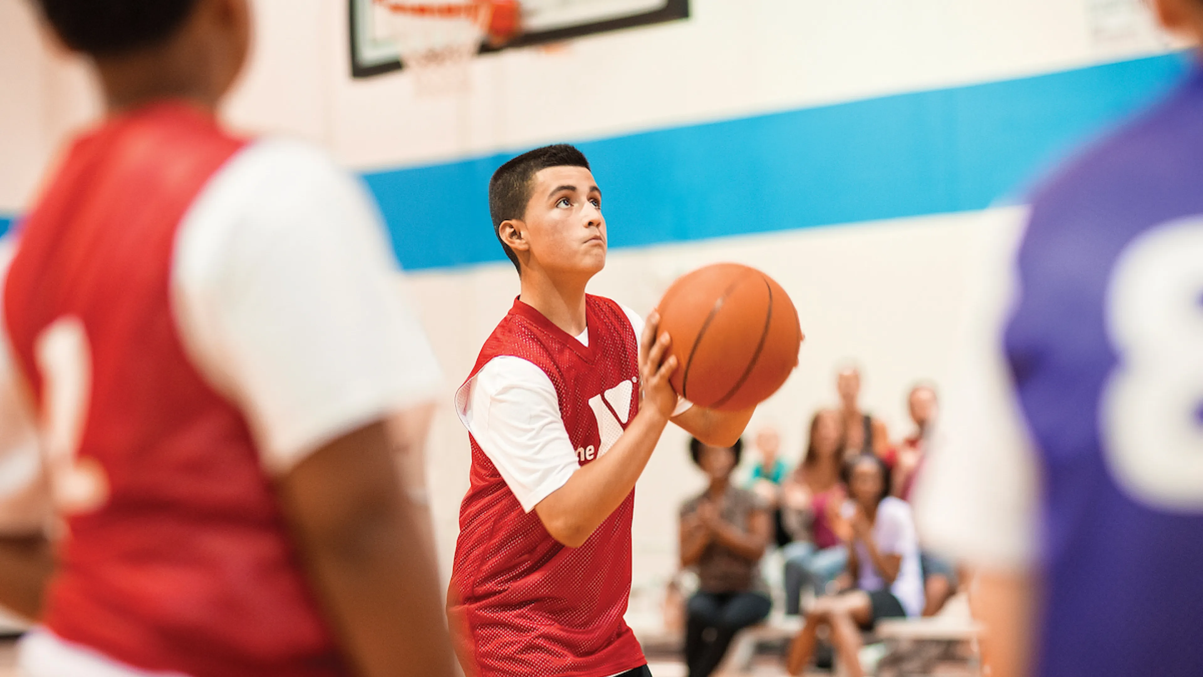 Kid shooting basketball during youth basketball league game