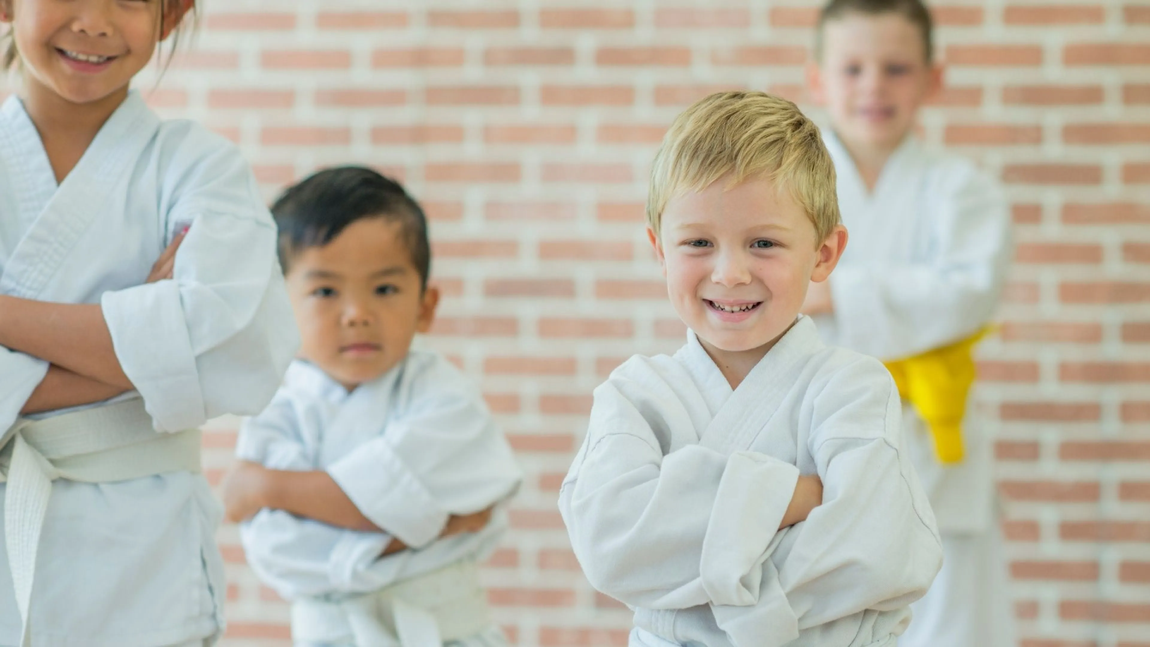 Smiling kids in white martial arts uniforms