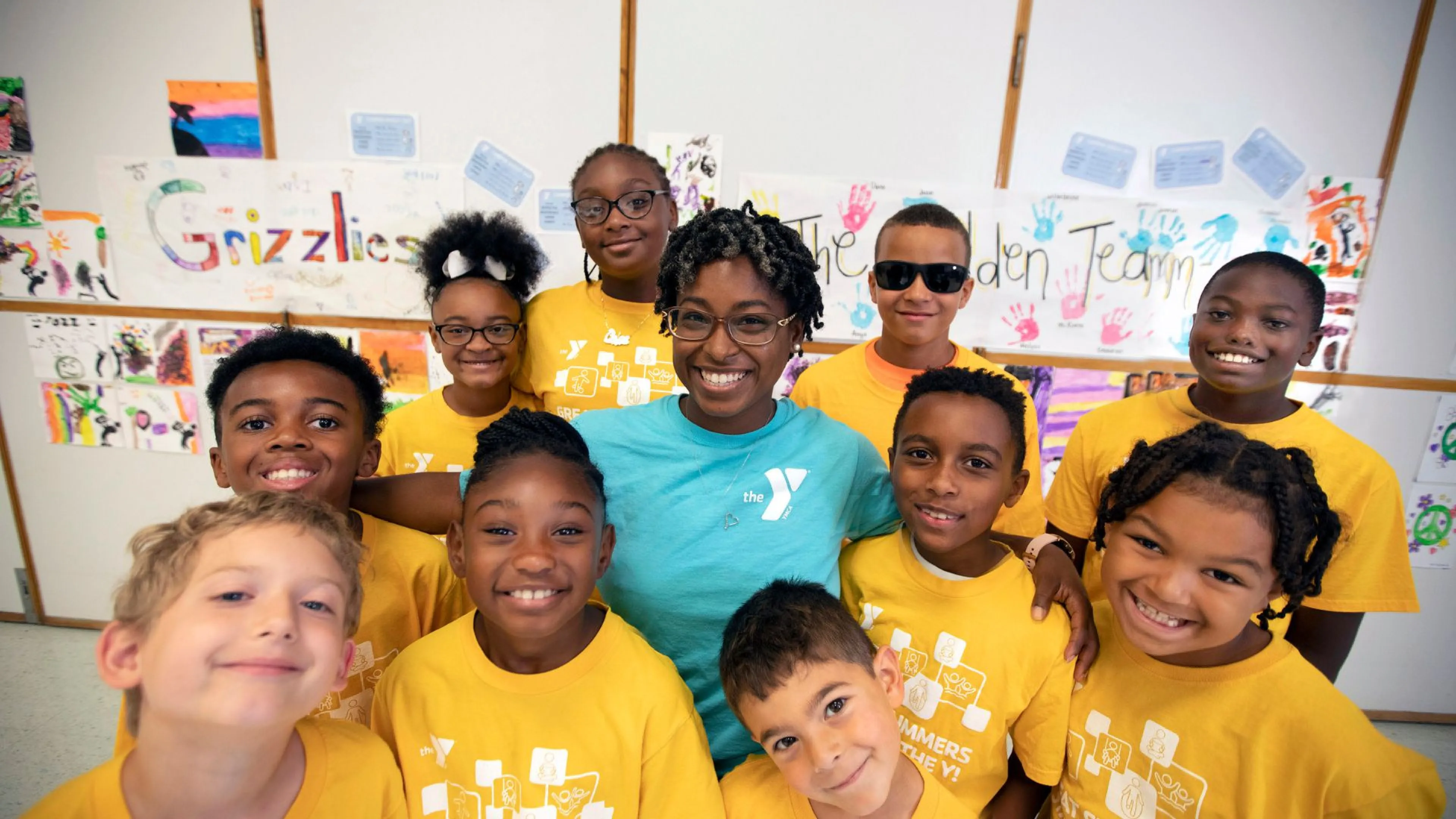Child care staff member standing with a group of children