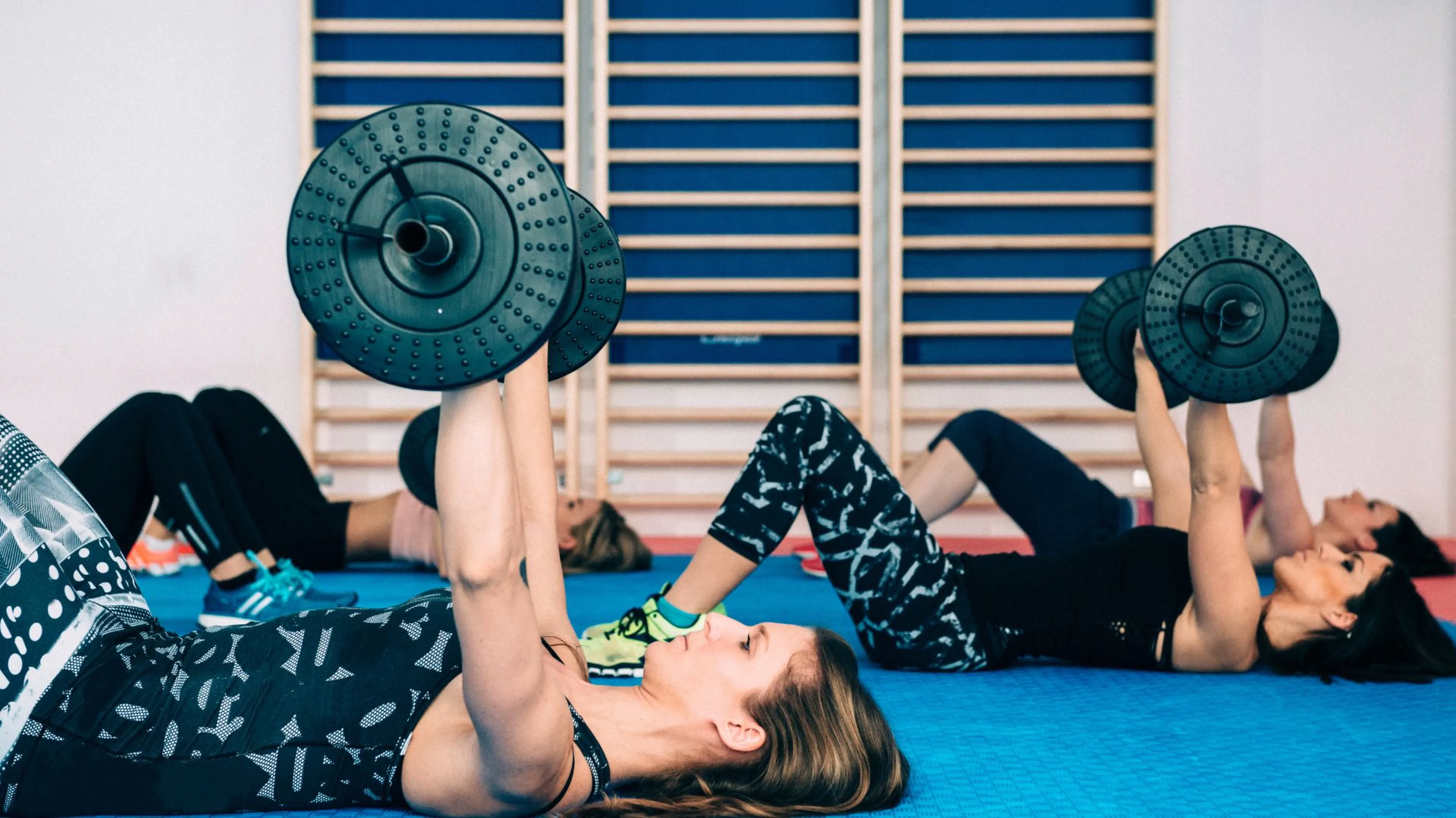 Women lifting barbells in YMCA strength group fitness class