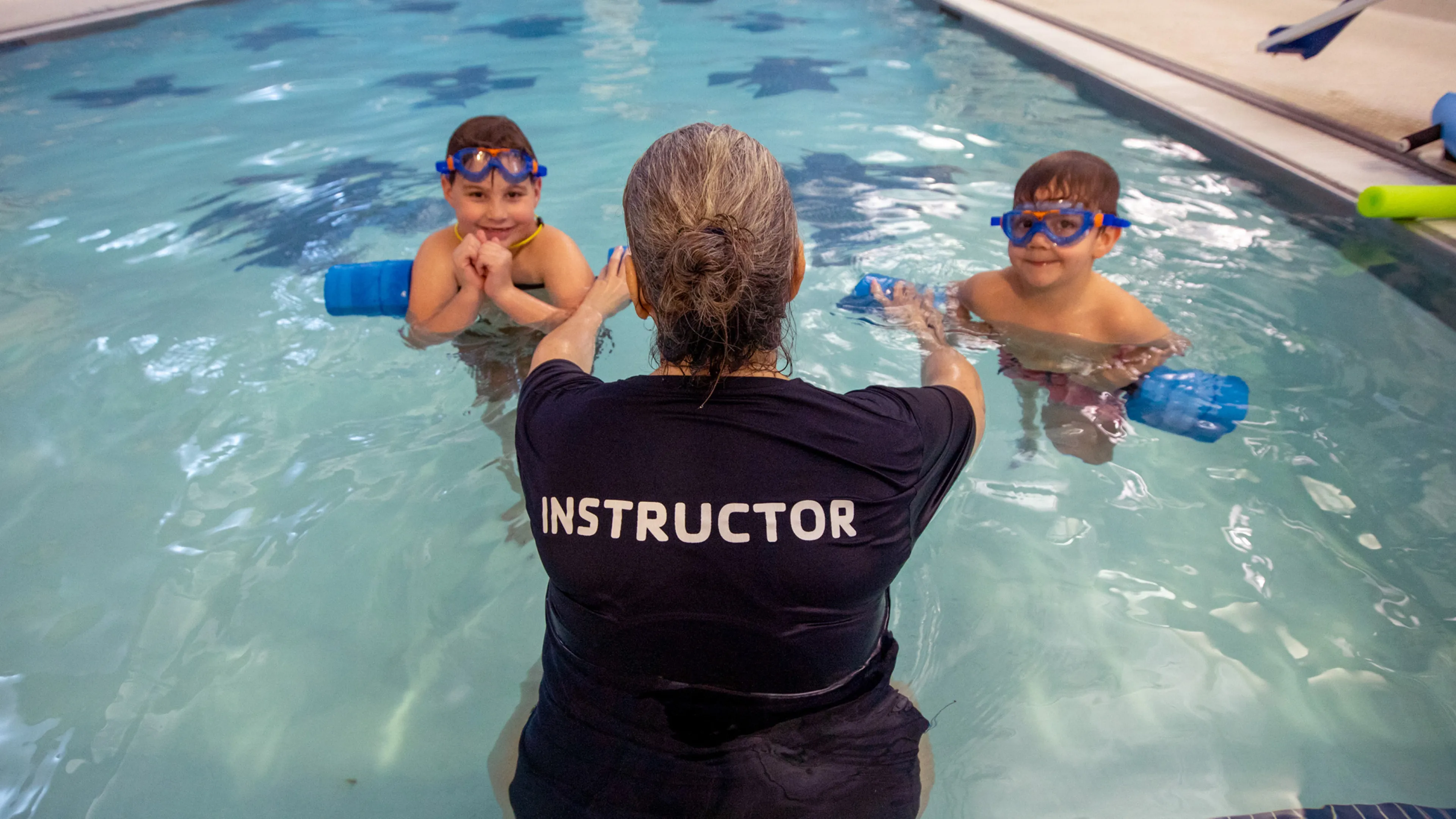 Swim instructor with two boys
