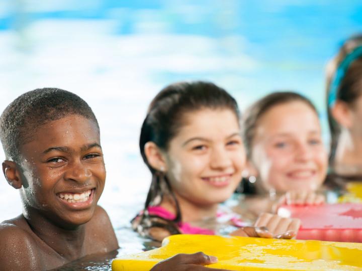 Group of smiling kids together in a pool