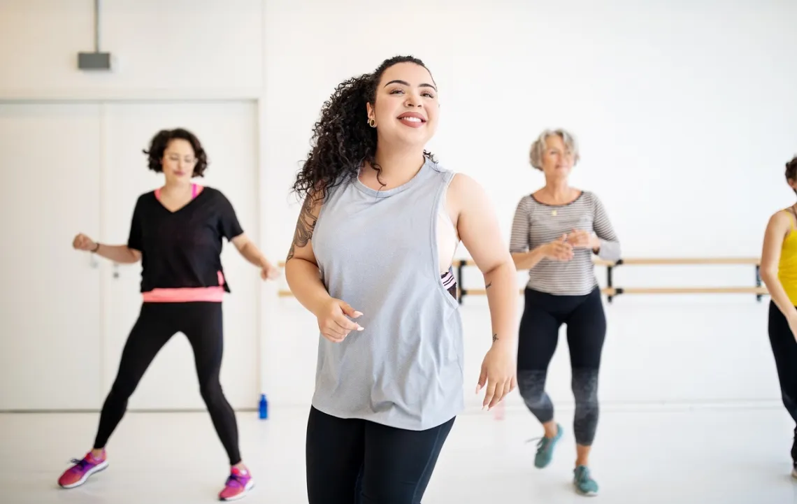 Adults and instructor flexing at group dance class at YMCA Louisville
